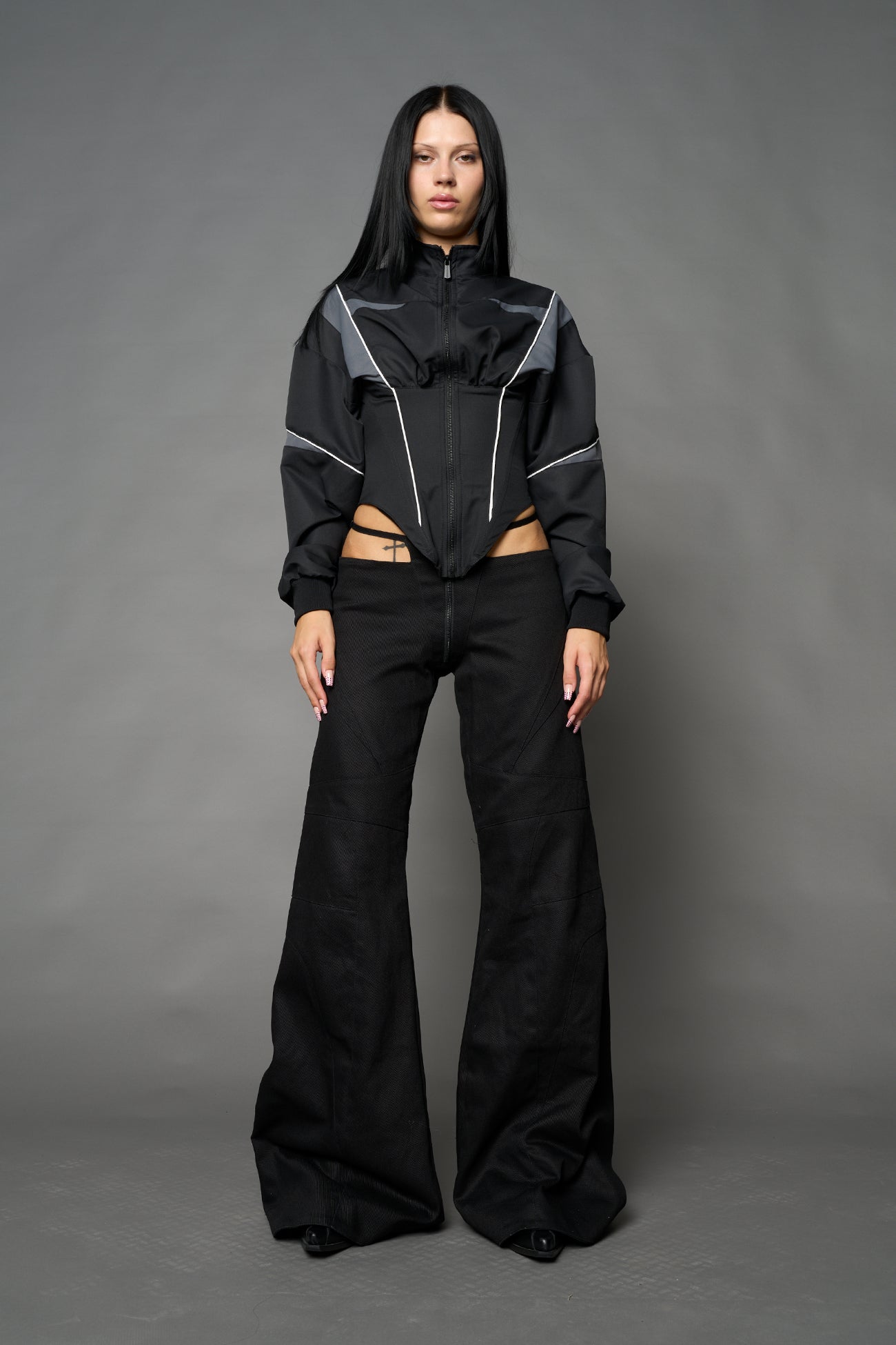 Black Namilia tracksuit jacket with grey sleeve stripes and lace-up corset back