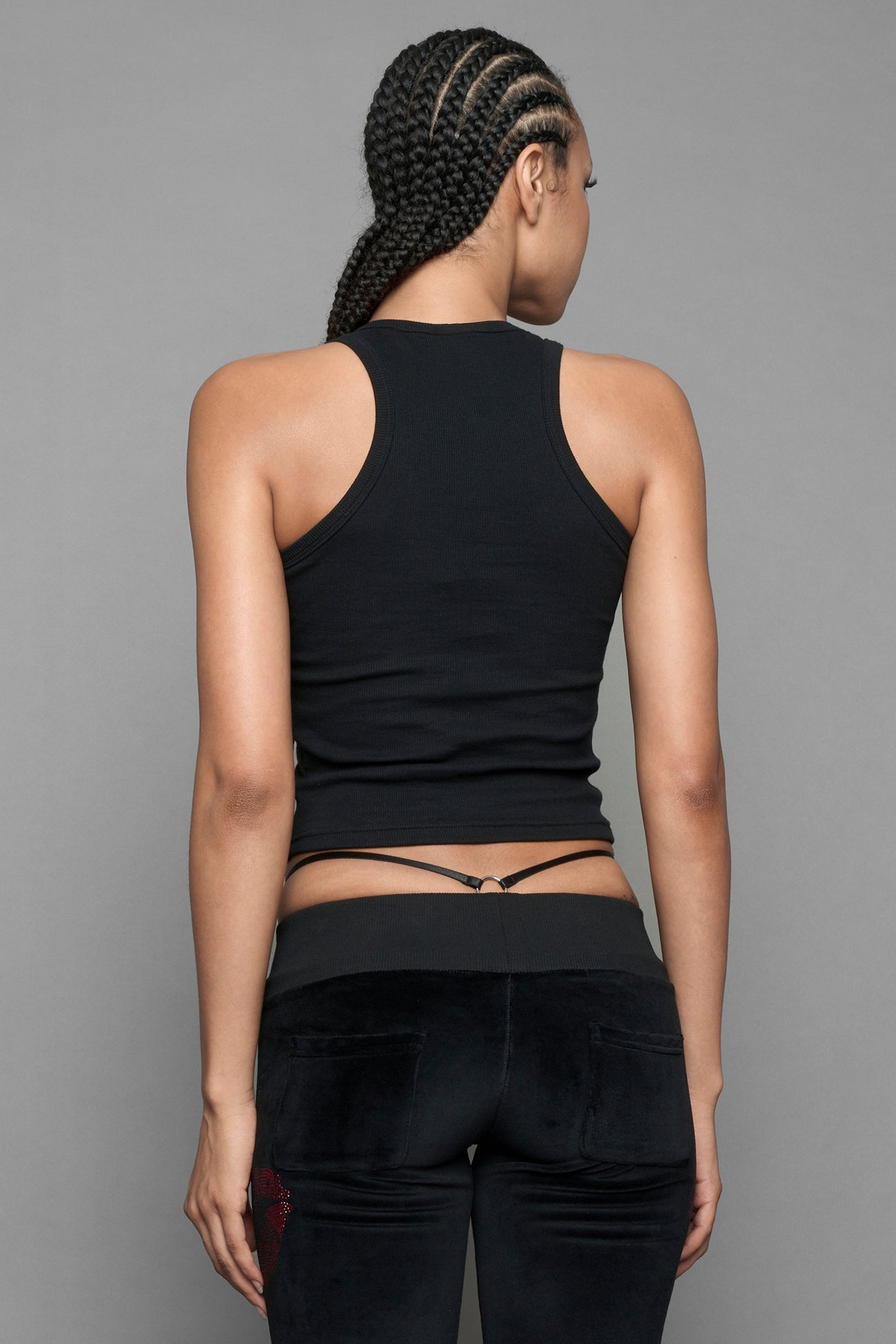 A model wearing a black halter crop top with red and silver 'I <heart> PLAYBOY Namilia' graphic, paired with black pants featuring a red lip print