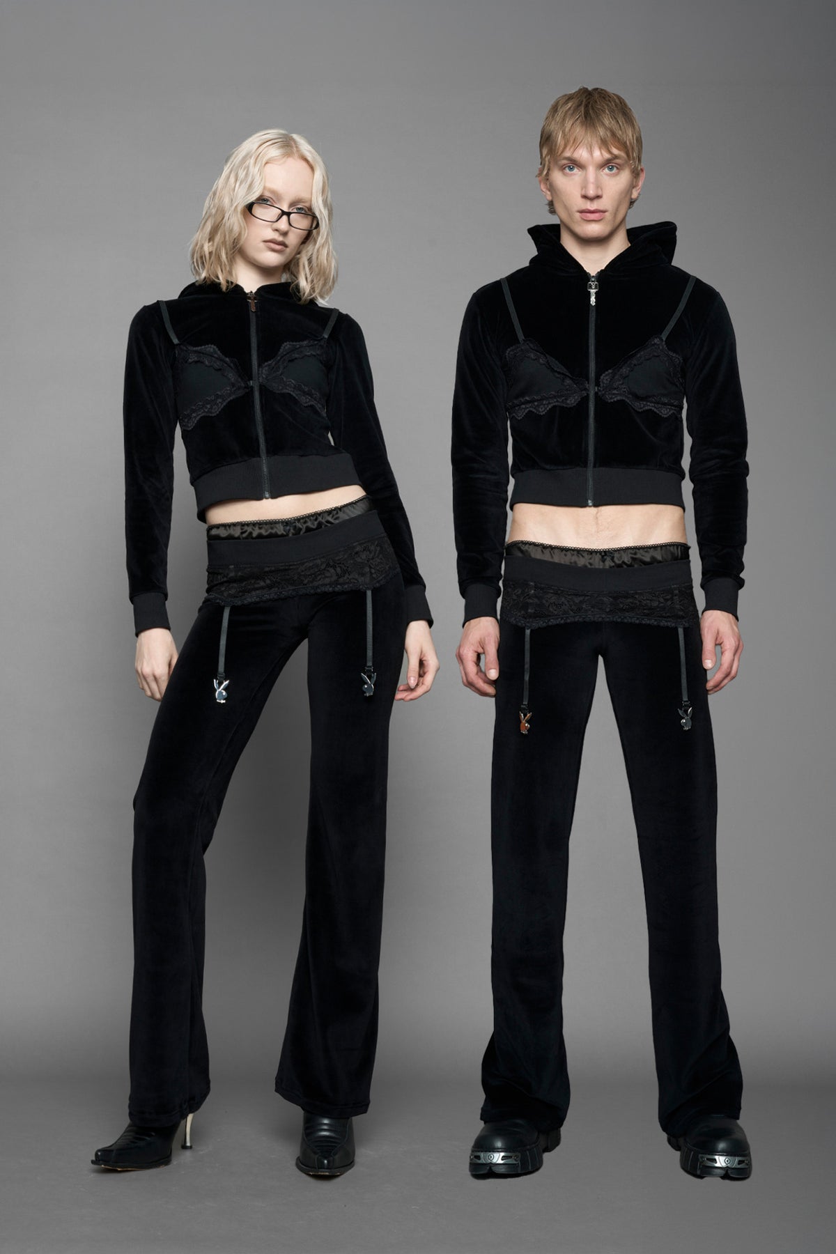 model wearing black velvet tracksuit pants with a lingerie black lace garter and suspenders with metal silver Bunnys