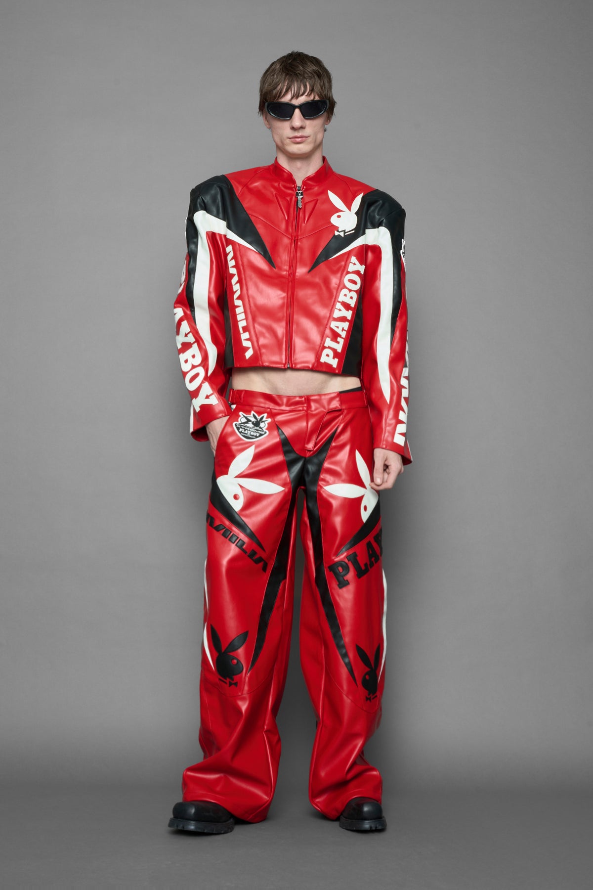 model is wearing red PU Leather pants with bold white Playboy bunny logos and white 'Namilia' Embroidery and rubber tag.