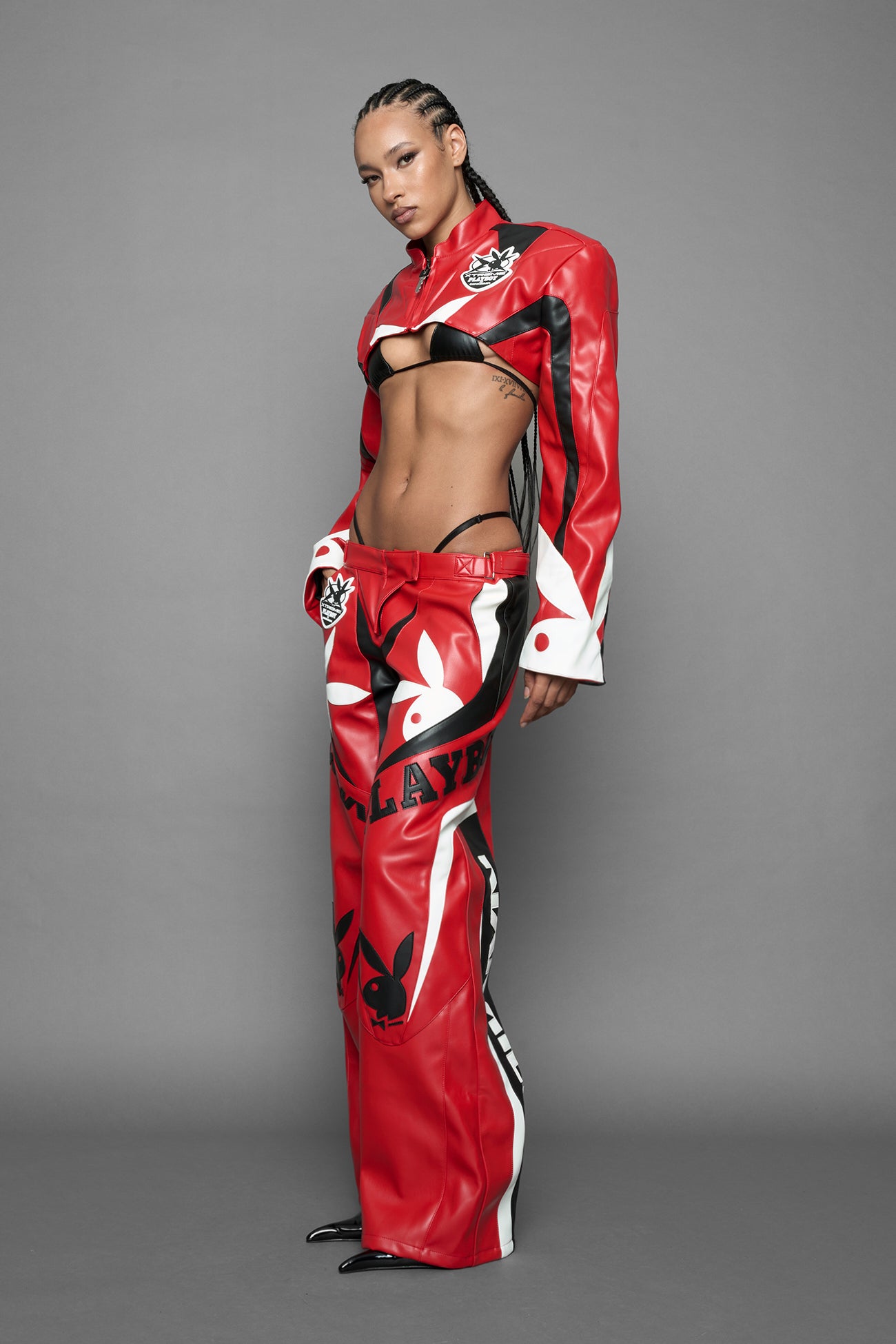 model is wearing red PU Leather pants with bold white Playboy bunny logos and white 'Namilia' Embroidery and rubber tag.