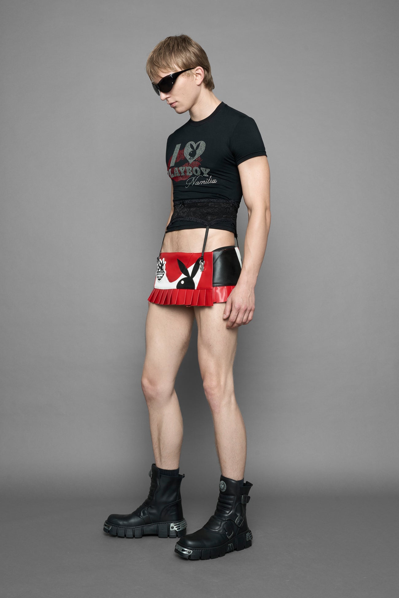 model wearing a red vegan leather wrap mini skirt with a black PU leather Bunny embroidery and a branded 'Playboy X Namilia' Rubbertag.