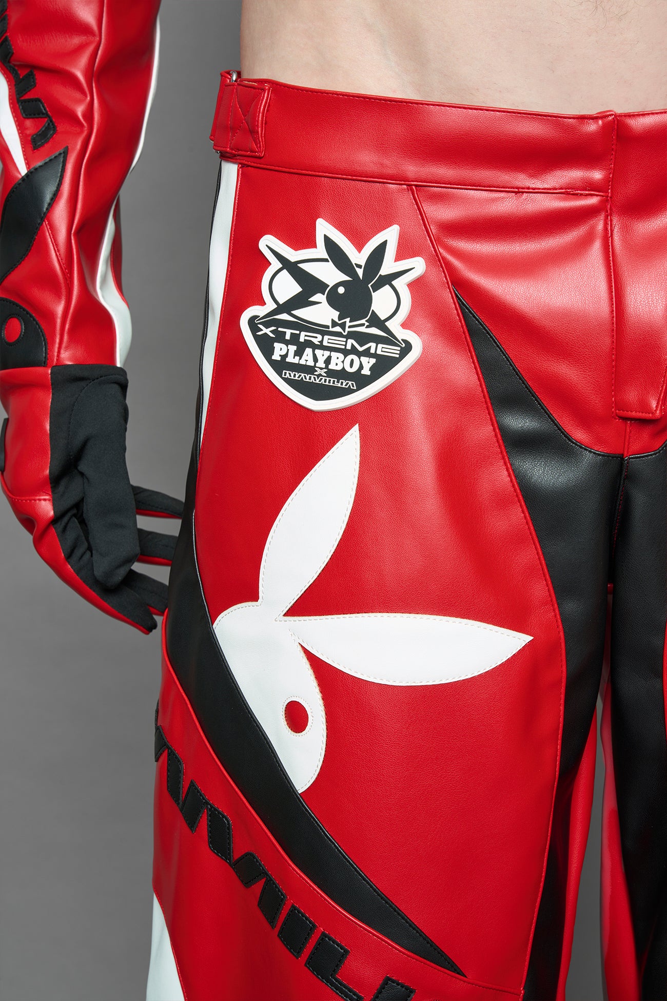 model is wearing red PU Leather pants with bold white Playboy bunny logos and white 'Namilia' Embroidery and rubber tag.
