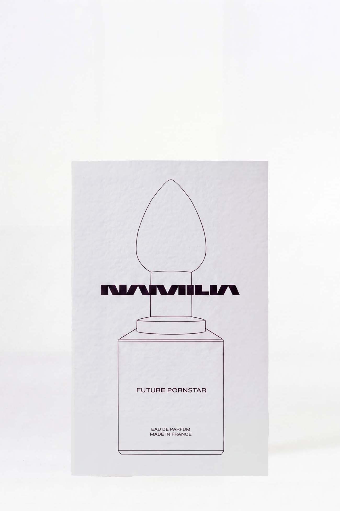 A bottle of Namilia Concrete CO2 Eau de Parfum with a large reflective black plug-shaped cap
