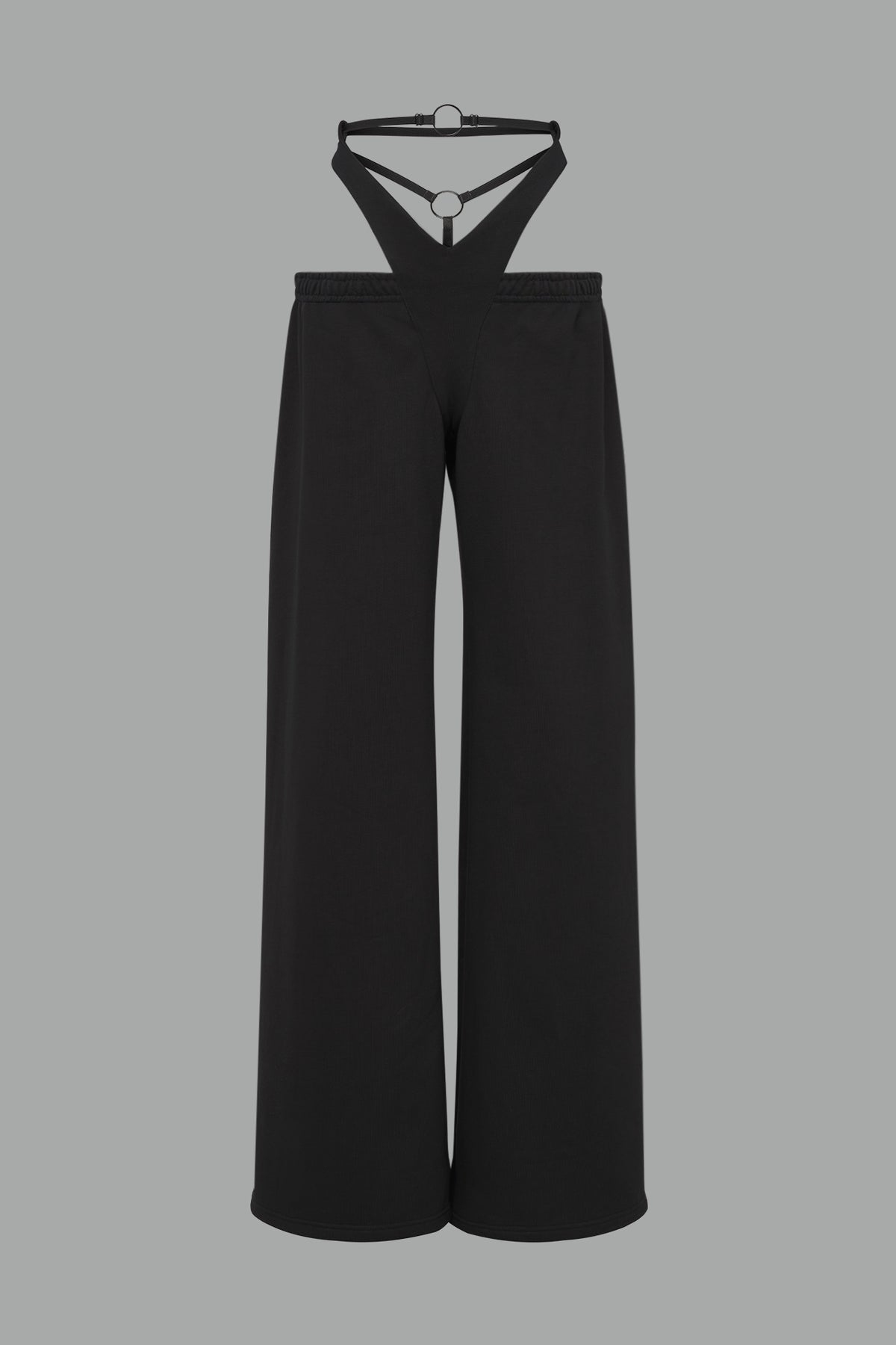 Model wearing low-rise black wide-leg pants featuring a V-shaped waistband and detachable thong strap detail.