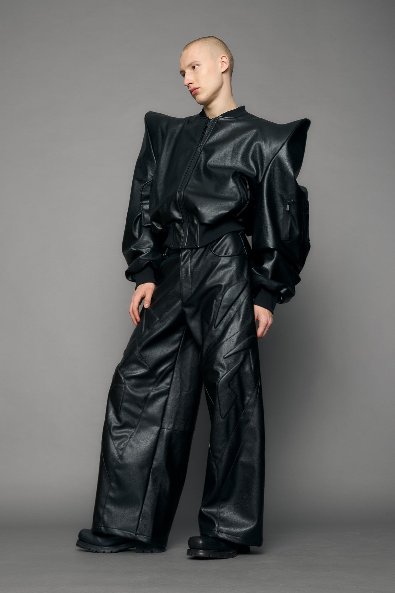 model wearing black pu leather bomber jacket with sharp shoulder design
