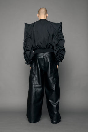 model wearing black bomber jacket with sharp shoulder design