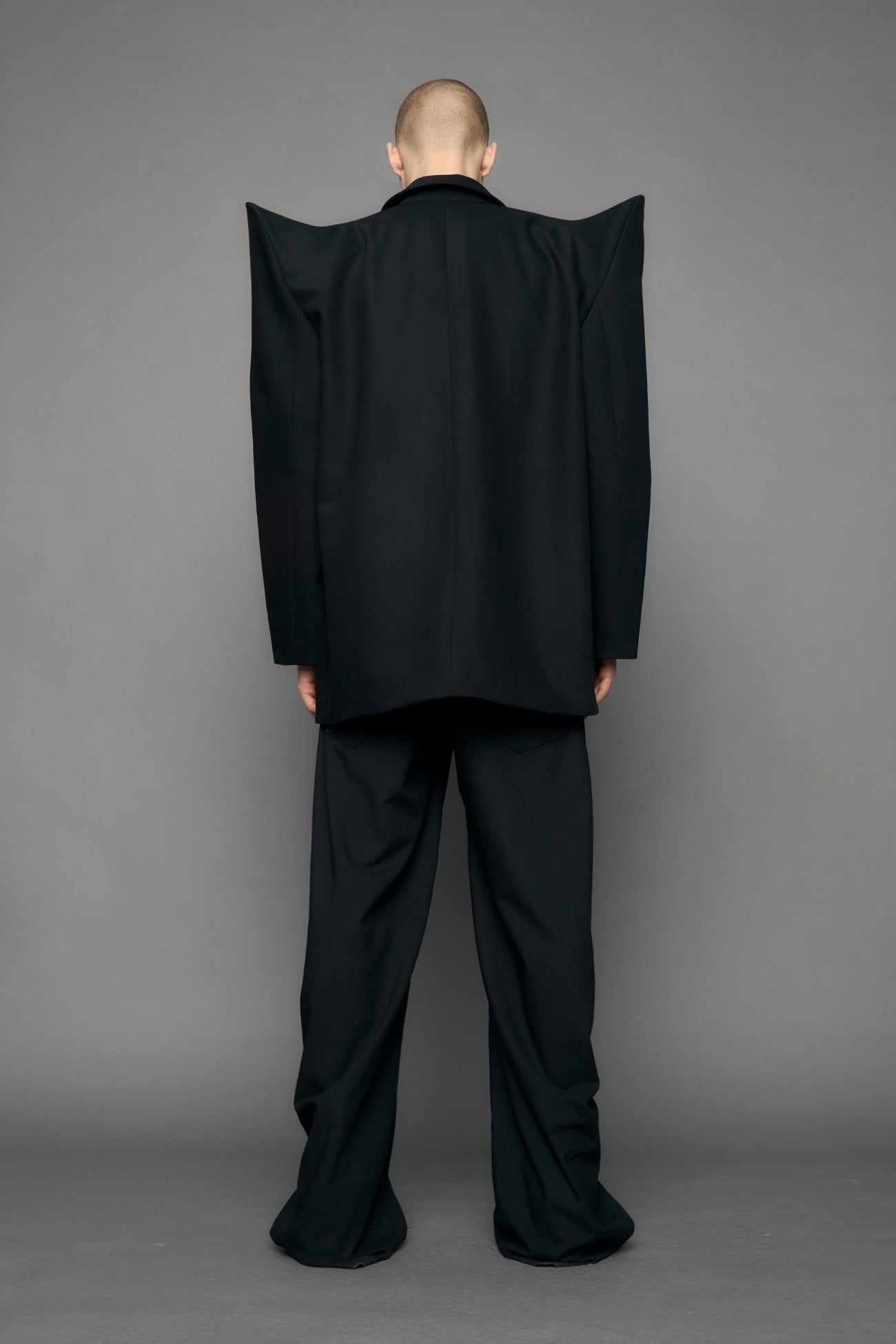 model wearing black blazer with sharp shoulder design