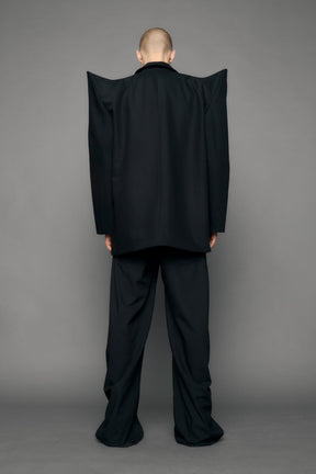 model wearing black blazer with sharp shoulder design
