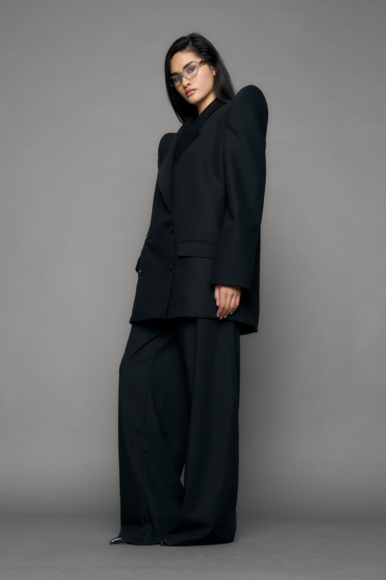 model wearing black blazer with sharp shoulder design