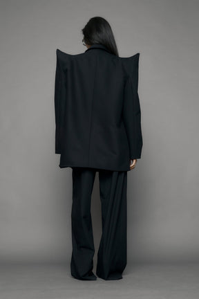 model wearing black blazer with sharp shoulder design