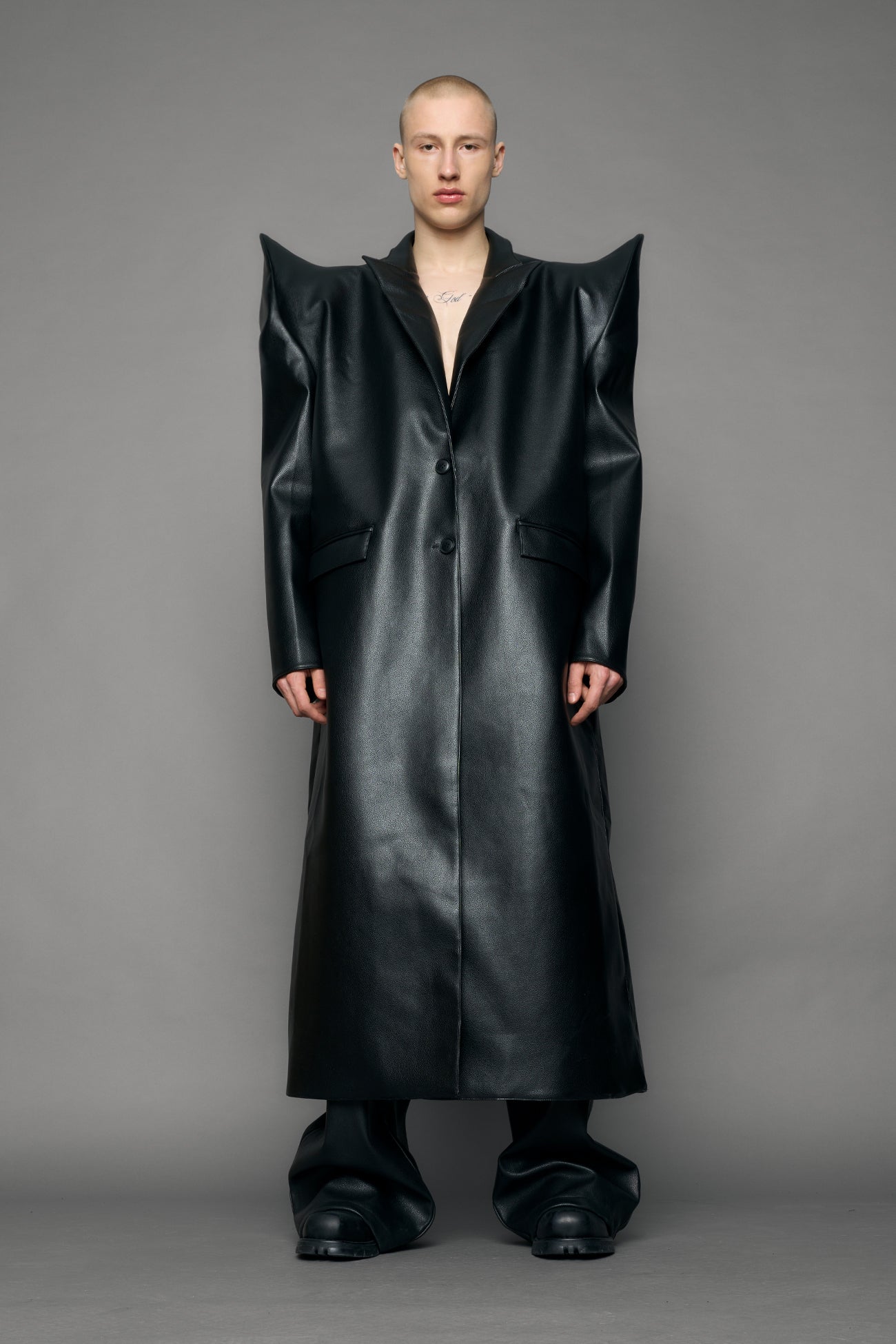 model wearing black pu leather coat with sharp shoulder design