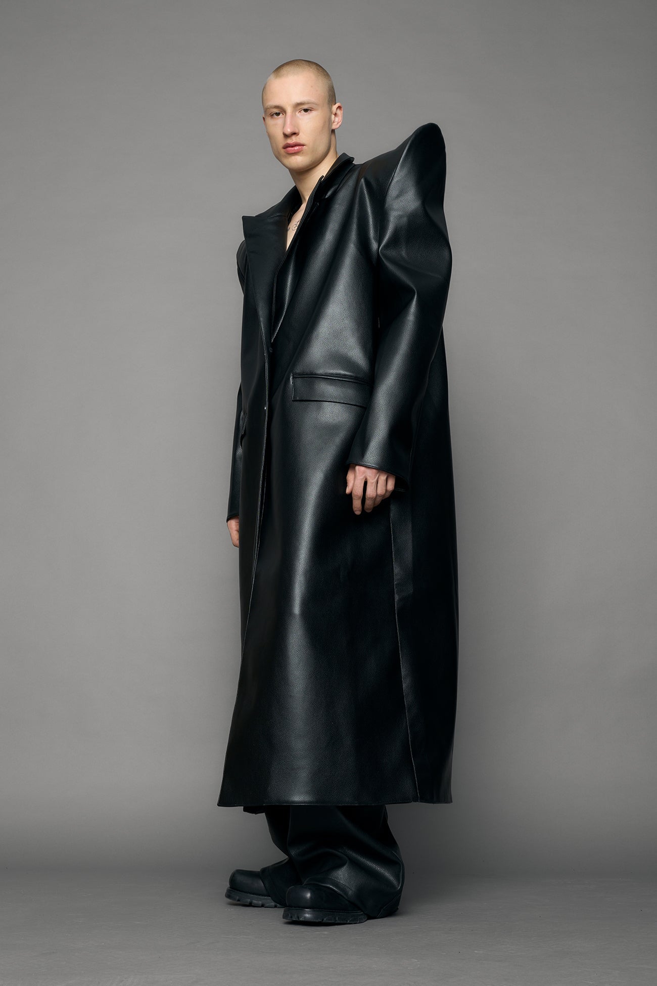 model wearing black pu leather coat with sharp shoulder design