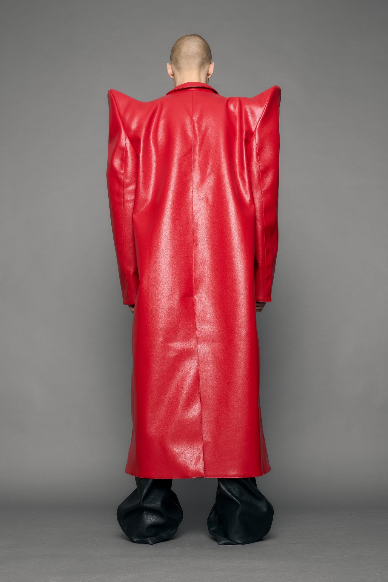 model wearing red pu leather coat with sharp shoulder design