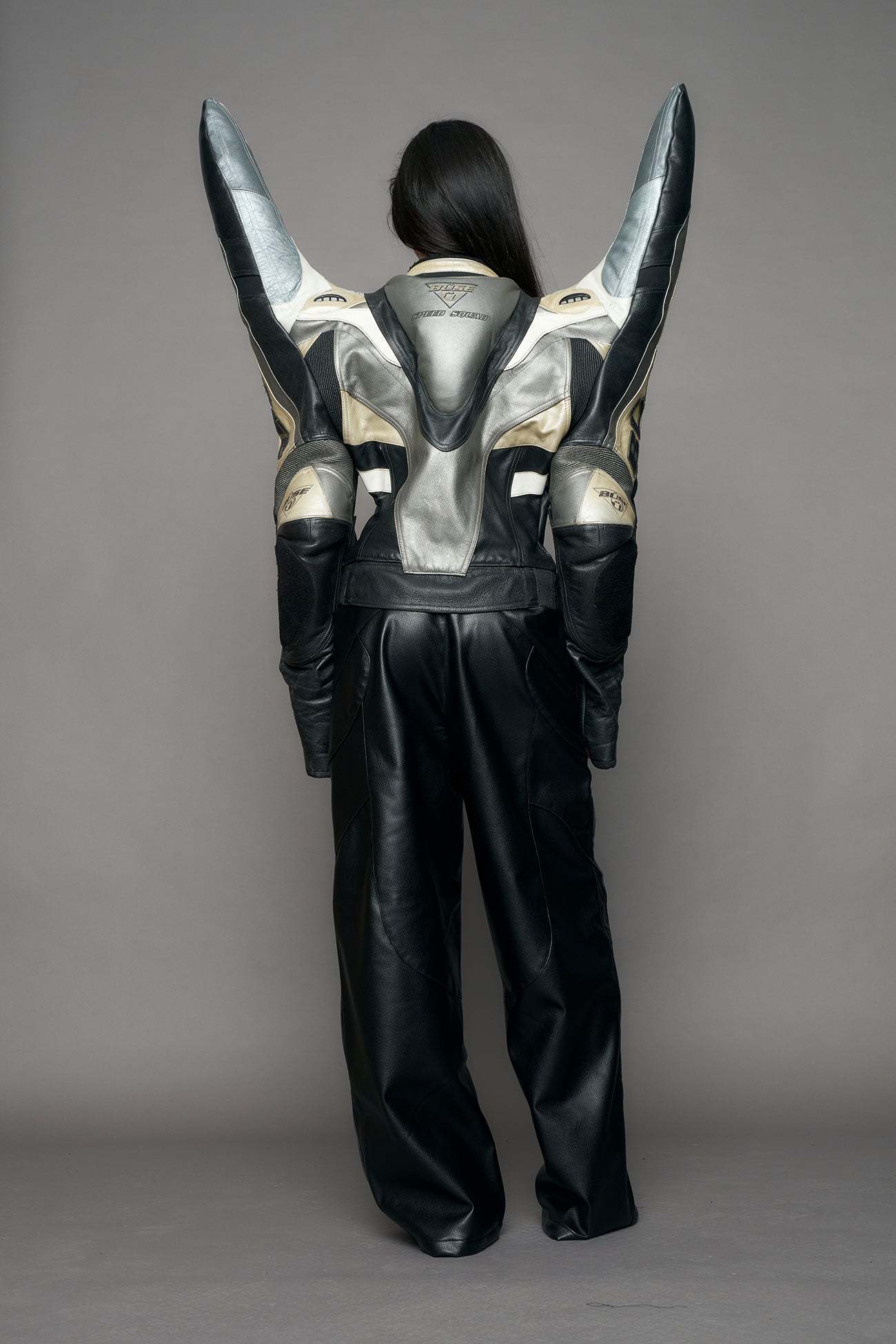 model wearing a motocross jacket with silver and black accents on a gray background