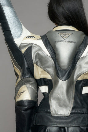 model wearing a motocross jacket with silver and black accents on a gray background