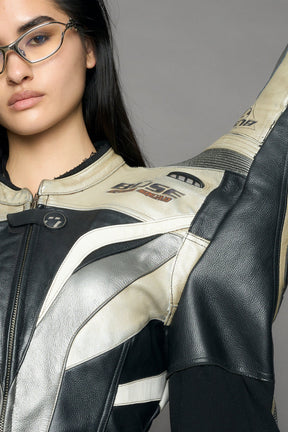 model wearing a motocross jacket with silver and black accents on a gray background