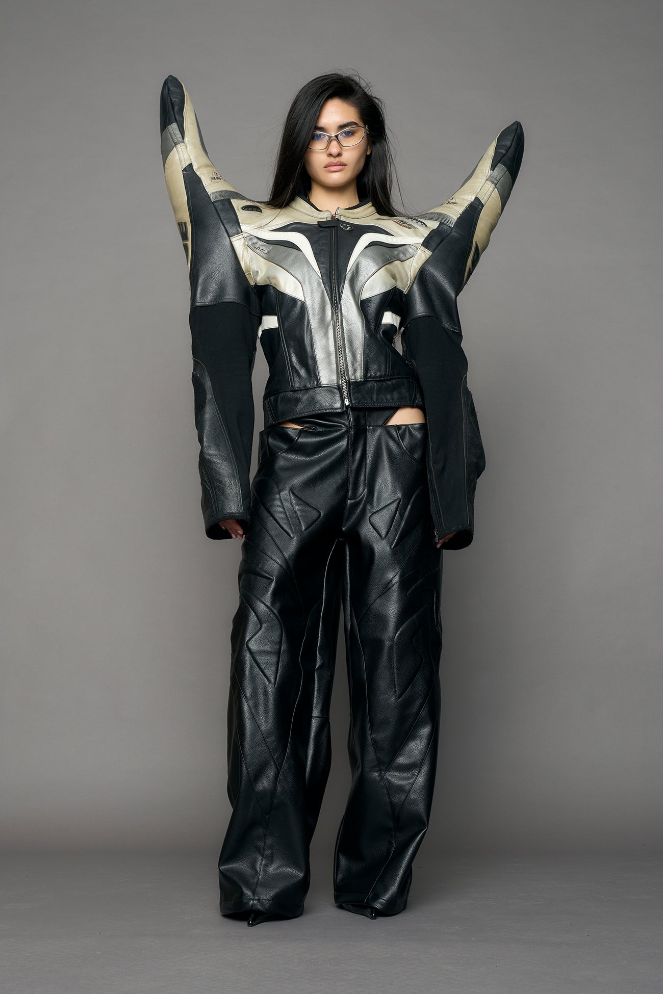model wearing a motocross jacket with silver and black accents on a gray background