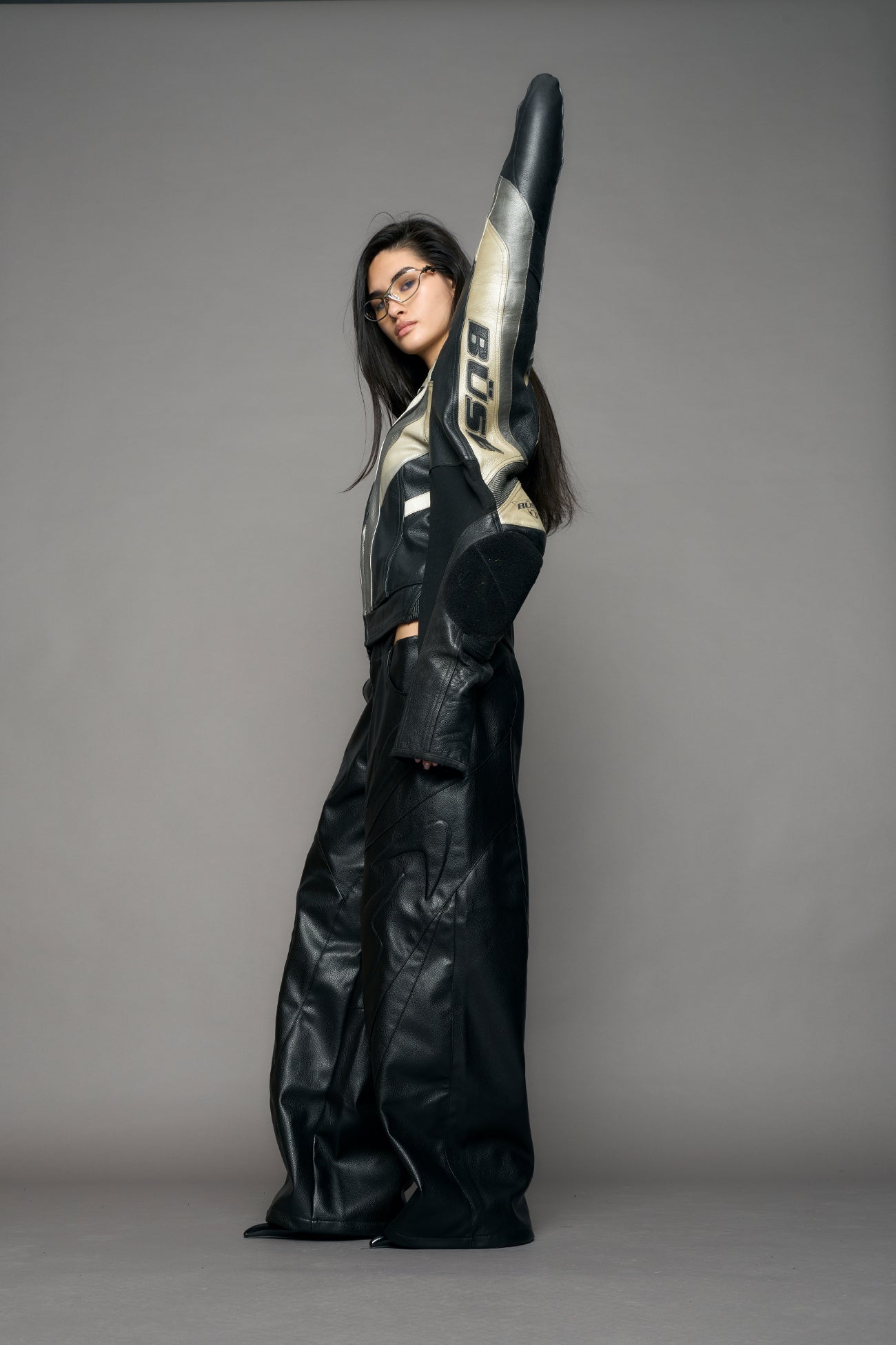 model wearing a motocross jacket with silver and black accents on a gray background