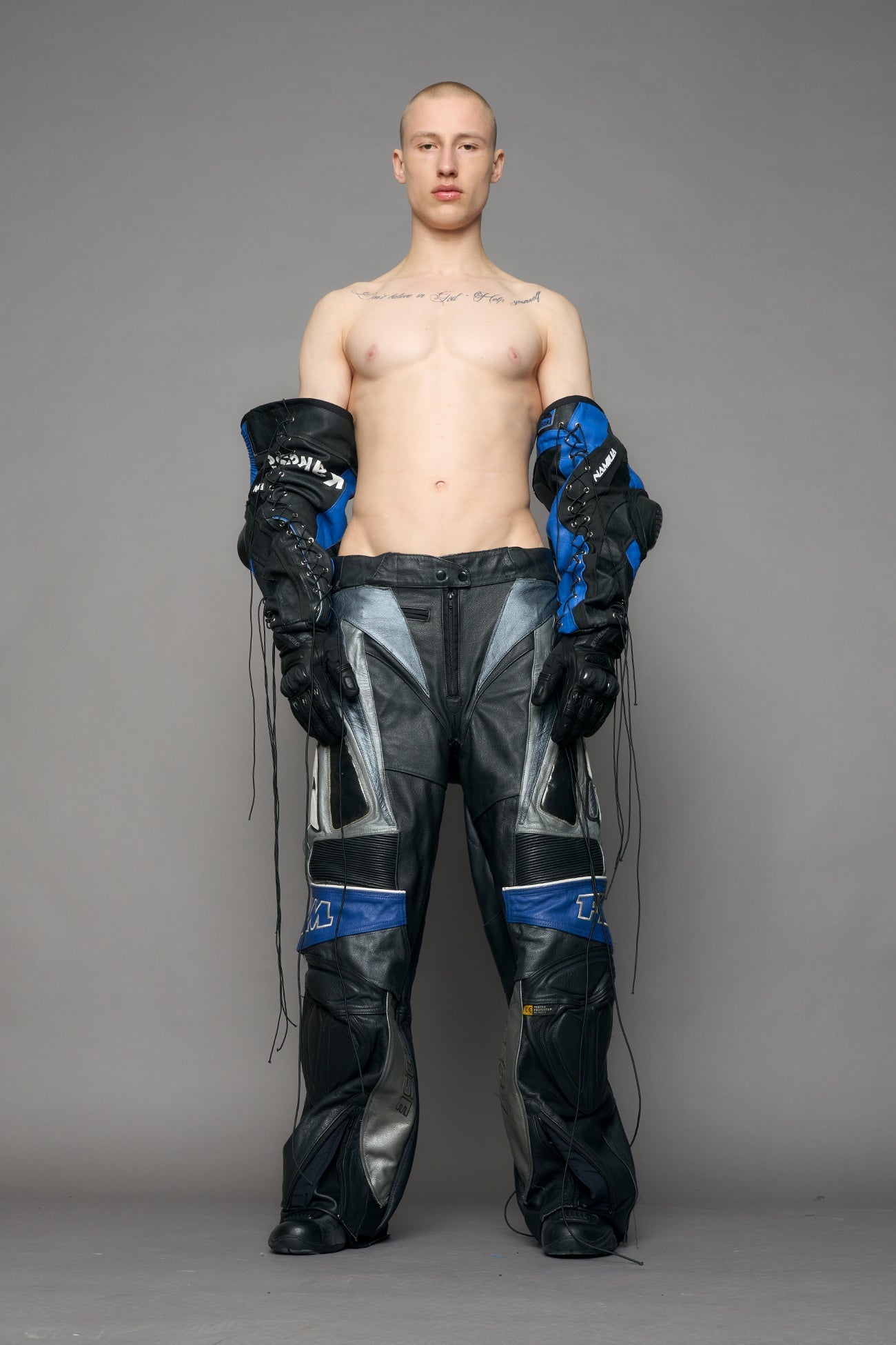 model wearing a motocross pants with silver and black accents on a gray background