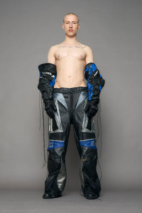 model wearing a motocross pants with silver and black accents on a gray background