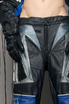 model wearing a motocross pants with silver and black accents on a gray background