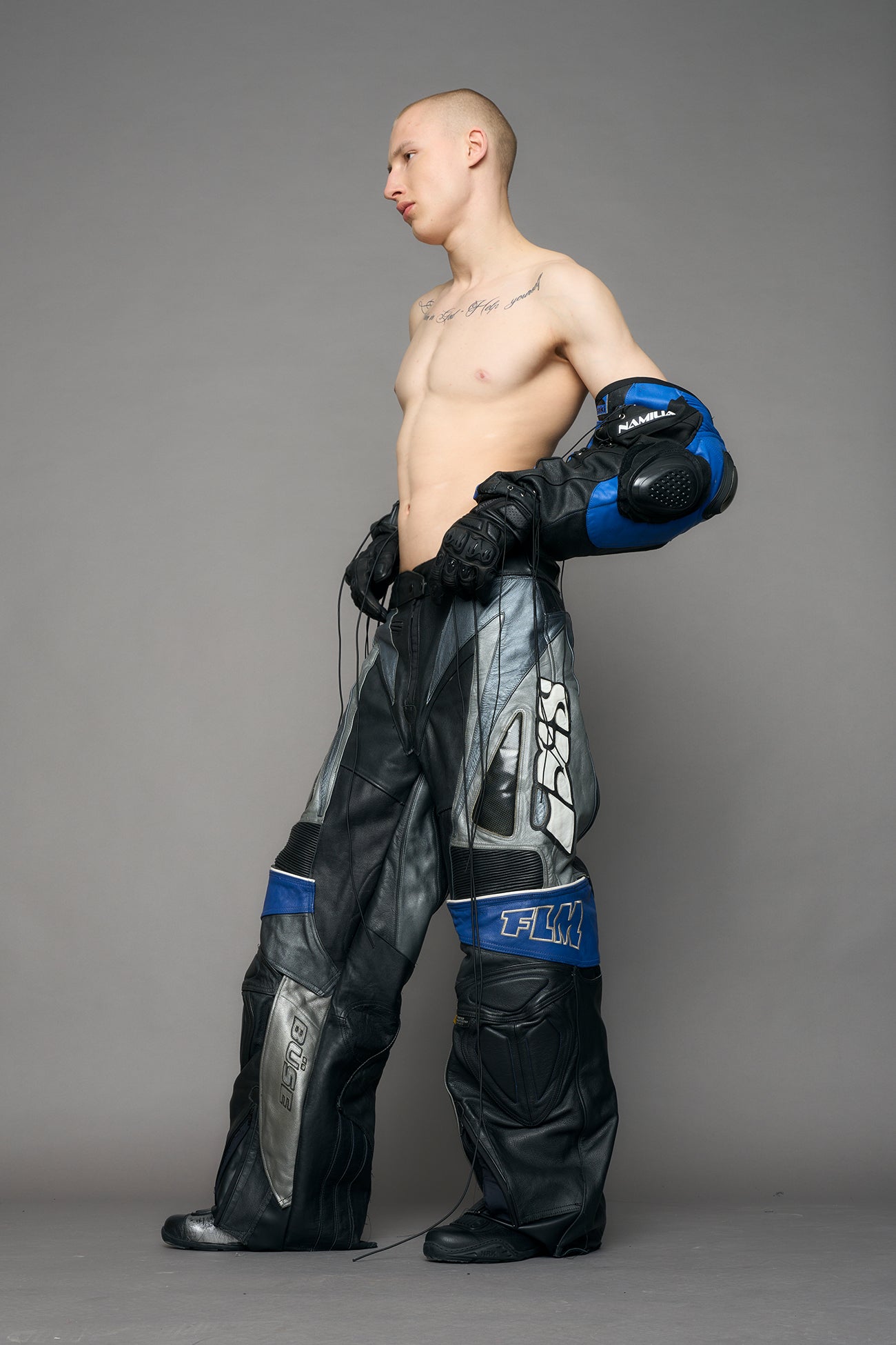 model wearing a motocross pants with silver and black accents on a gray background