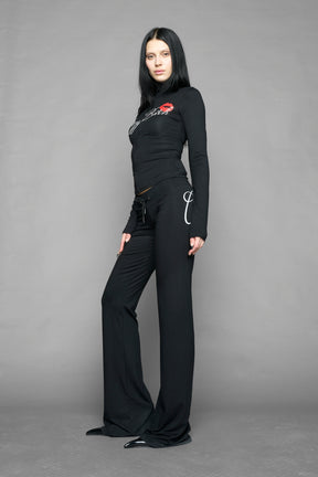 black crazy jersey pants with high waist rib waistband drawstring and back graphic print on model studio ecom photo