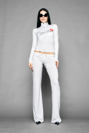 white crazy jersey pants with high waist rib waistband drawstring and back graphic print on model studio ecom photo
