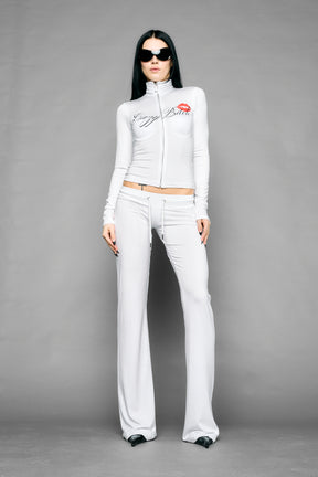white crazy jersey pants with high waist rib waistband drawstring and back graphic print on model studio ecom photo