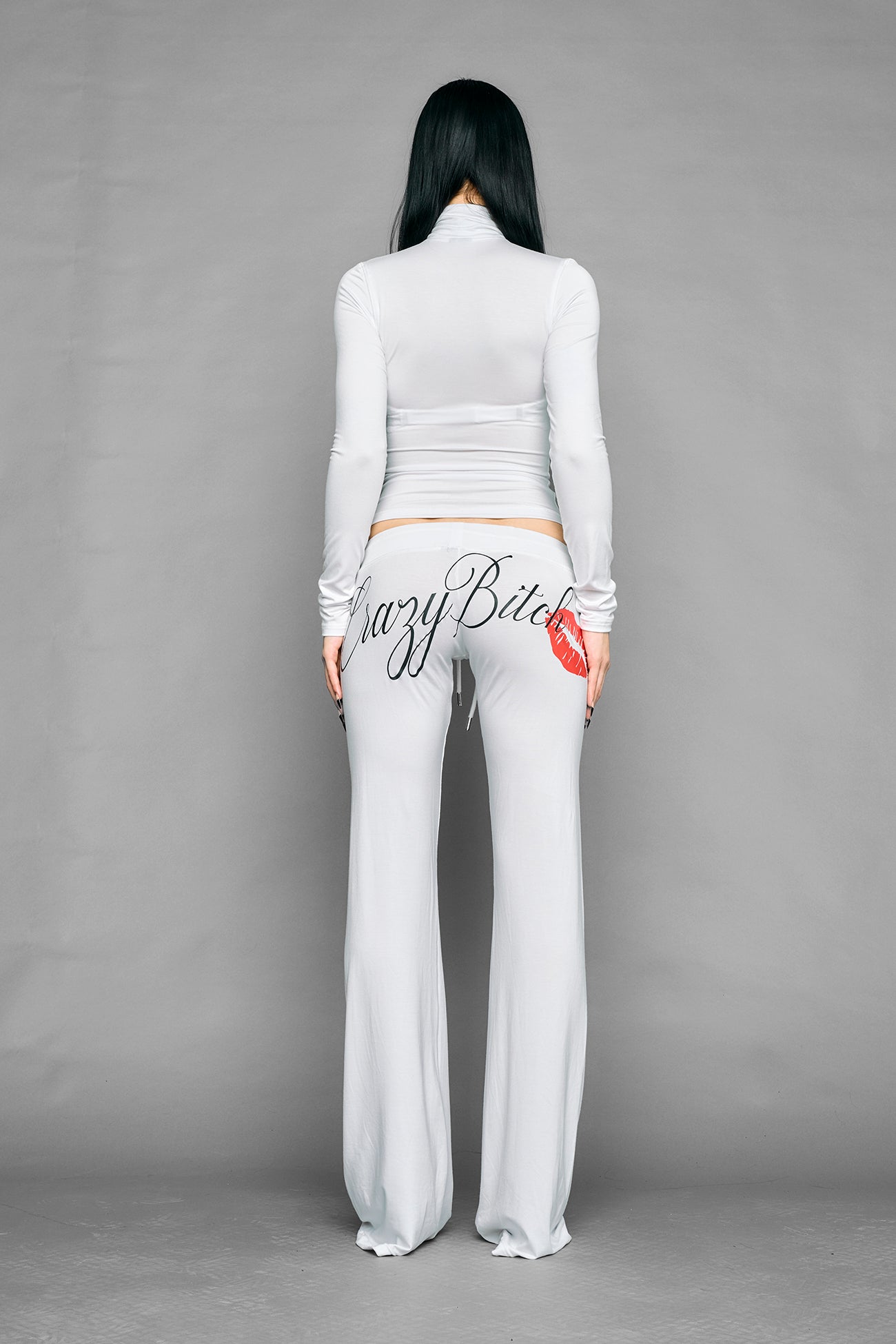 white crazy jersey pants with high waist rib waistband drawstring and back graphic print on model studio ecom photo