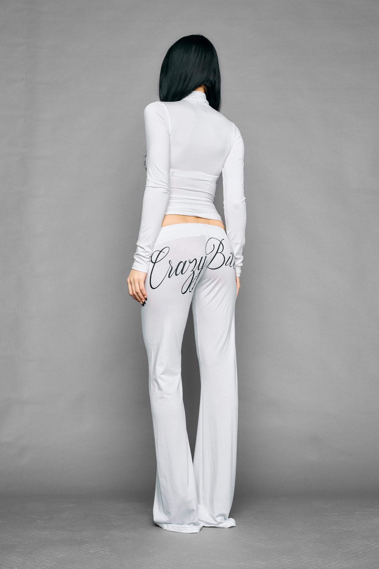 white crazy jersey pants with high waist rib waistband drawstring and back graphic print on model studio ecom photo