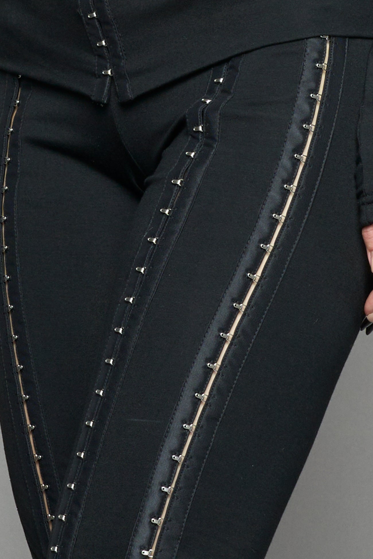 black hook tape jersey pants with slim fit and hook and eye detailing along legs worn by model studio ecommerce image