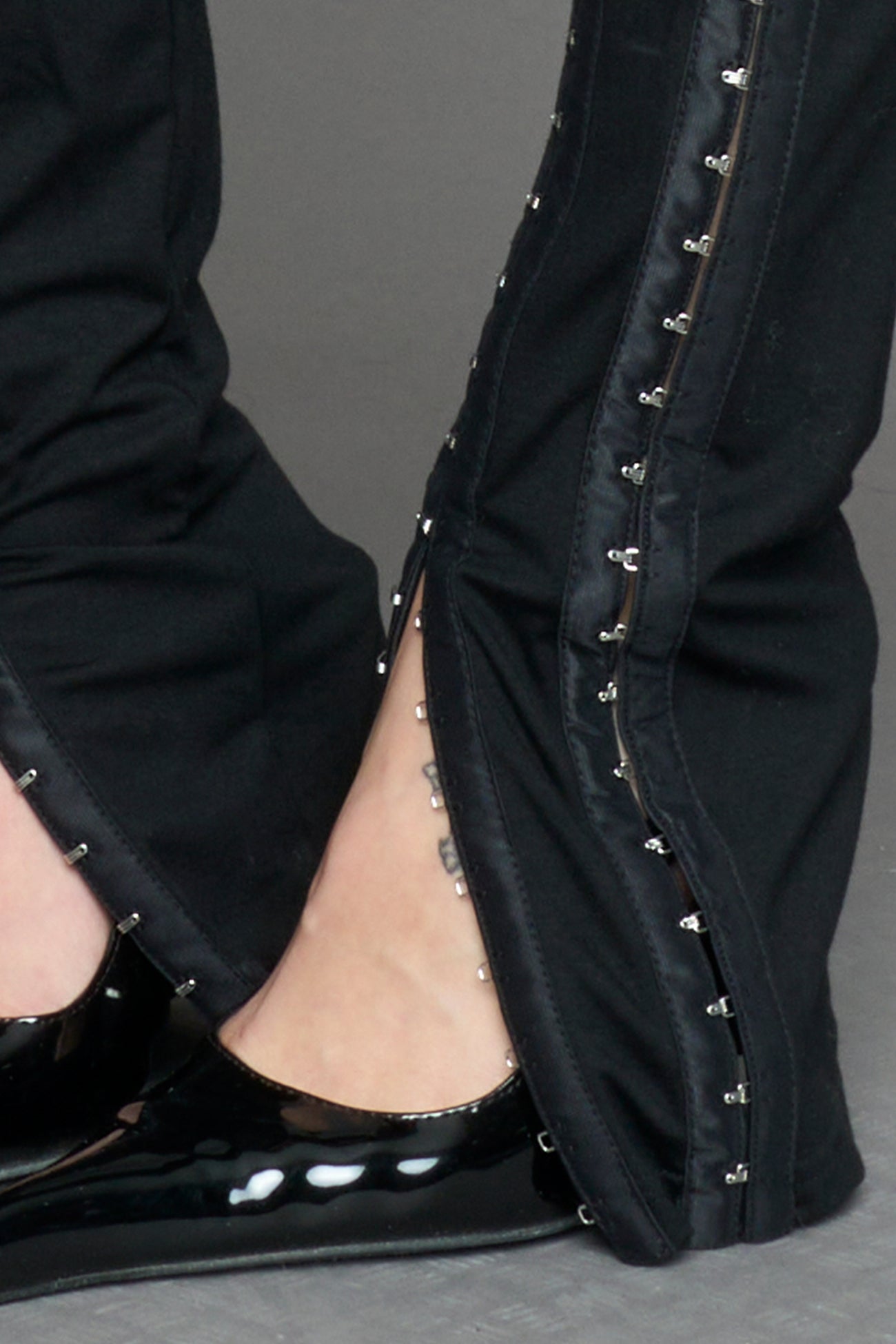 black hook tape jersey pants with slim fit and hook and eye detailing along legs worn by model studio ecommerce image