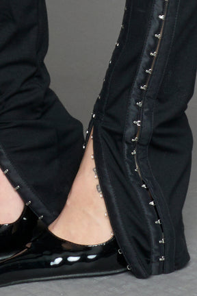 black hook tape jersey pants with slim fit and hook and eye detailing along legs worn by model studio ecommerce image