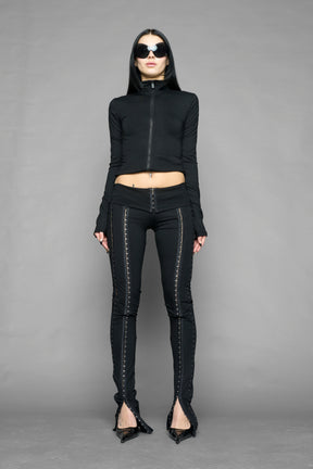 black hook tape jersey pants with slim fit and hook and eye detailing along legs worn by model studio ecommerce image