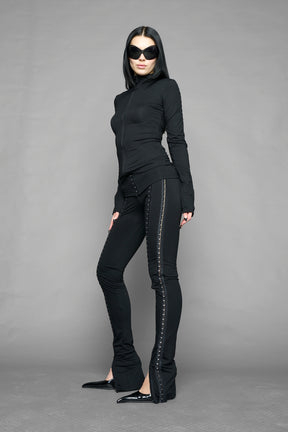 black hook tape jersey pants with slim fit and hook and eye detailing along legs worn by model studio ecommerce image