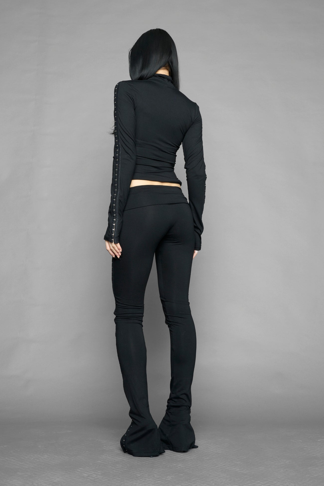 black hook tape jersey pants with slim fit and hook and eye detailing along legs worn by model studio ecommerce image