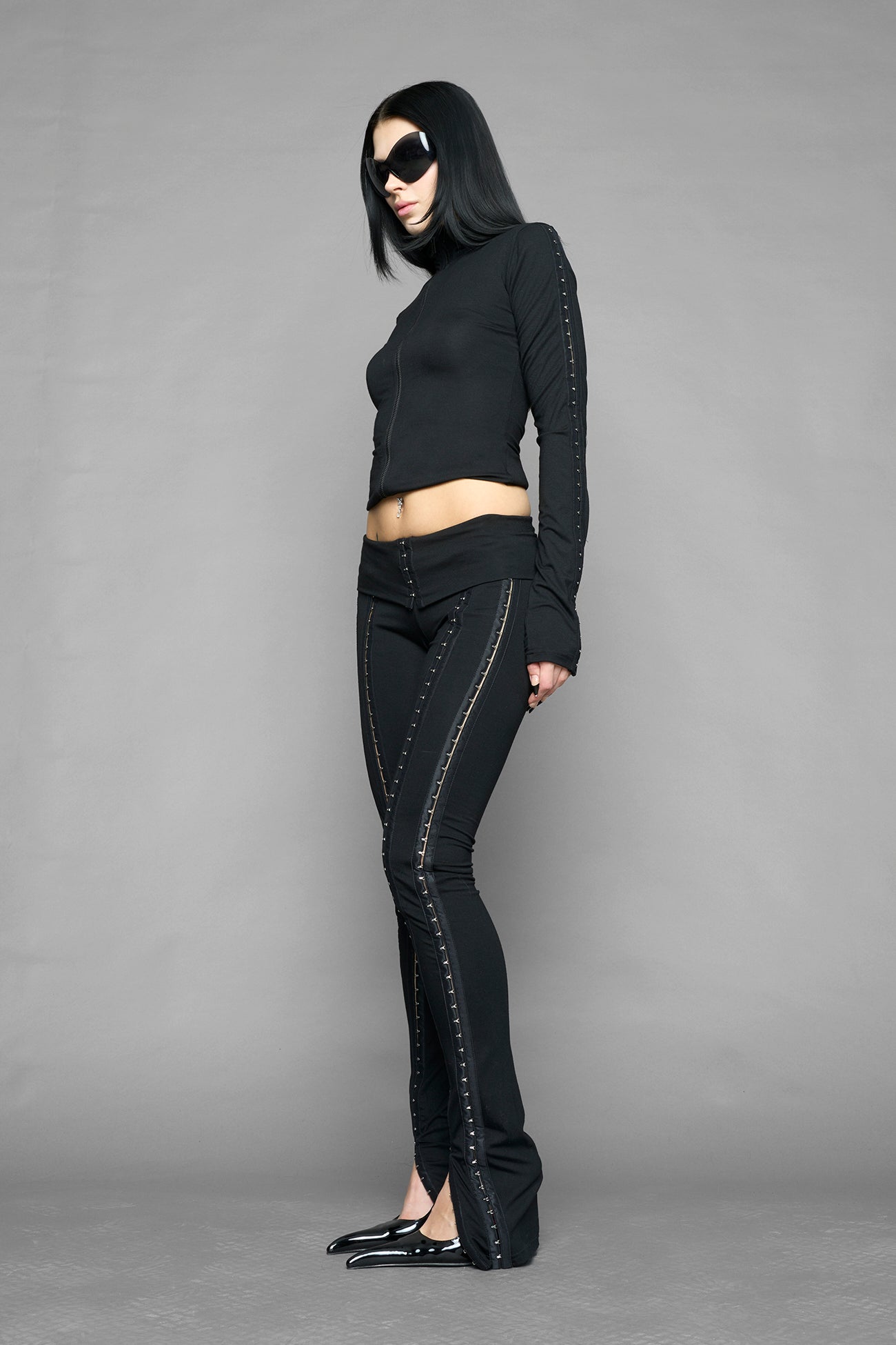 black hook tape jersey pants with slim fit and hook and eye detailing along legs worn by model studio ecommerce image