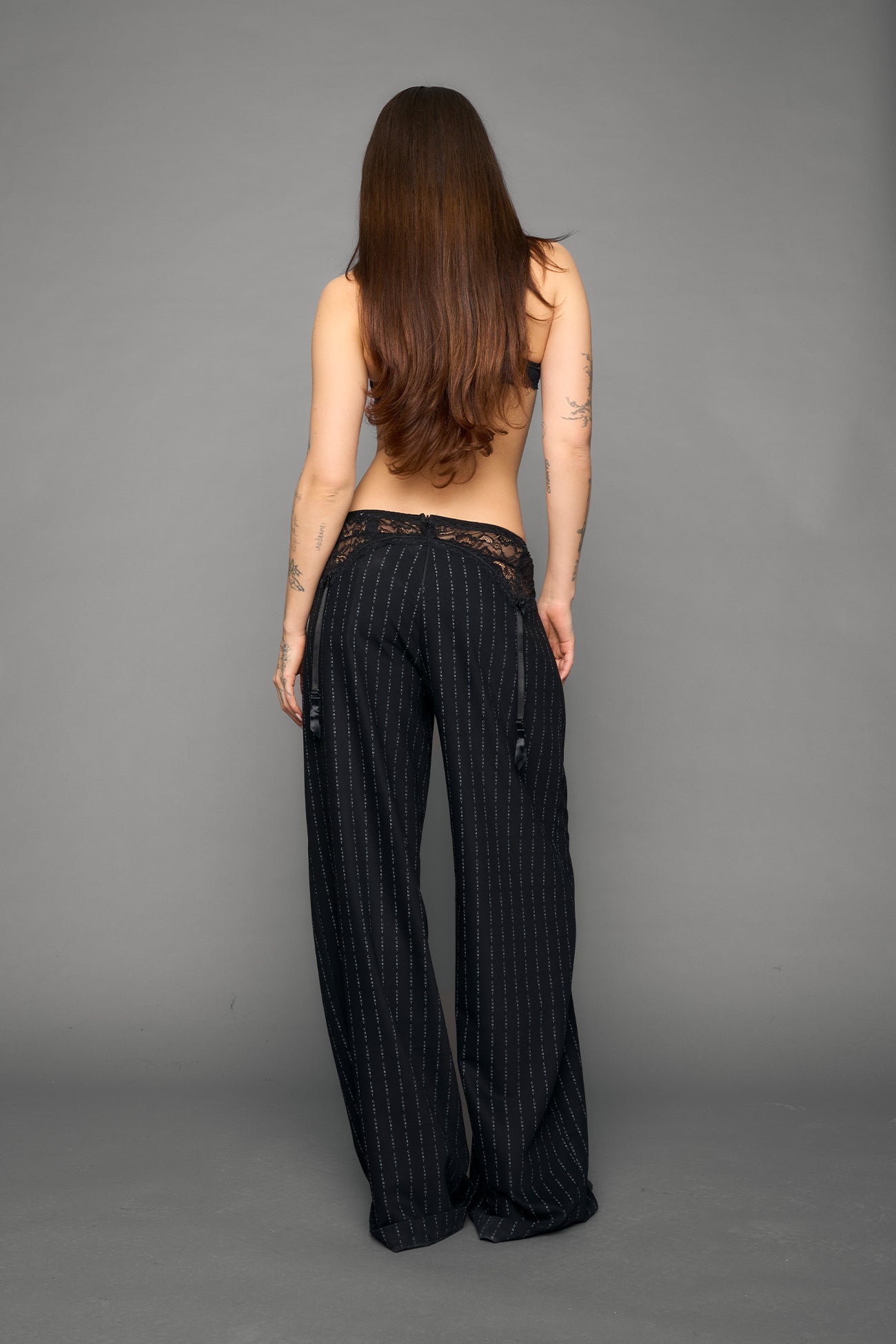 model wearing black print baggy suiting pants with garter lace waist detail