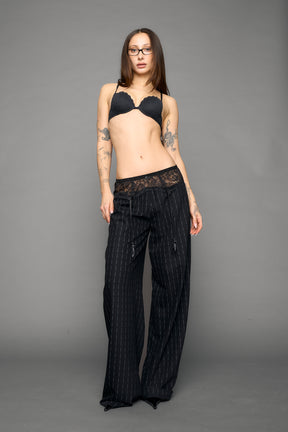 model wearing black print baggy suiting pants with garter lace waist detail