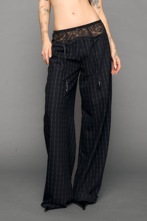 model wearing black print baggy suiting pants with garter lace waist detail