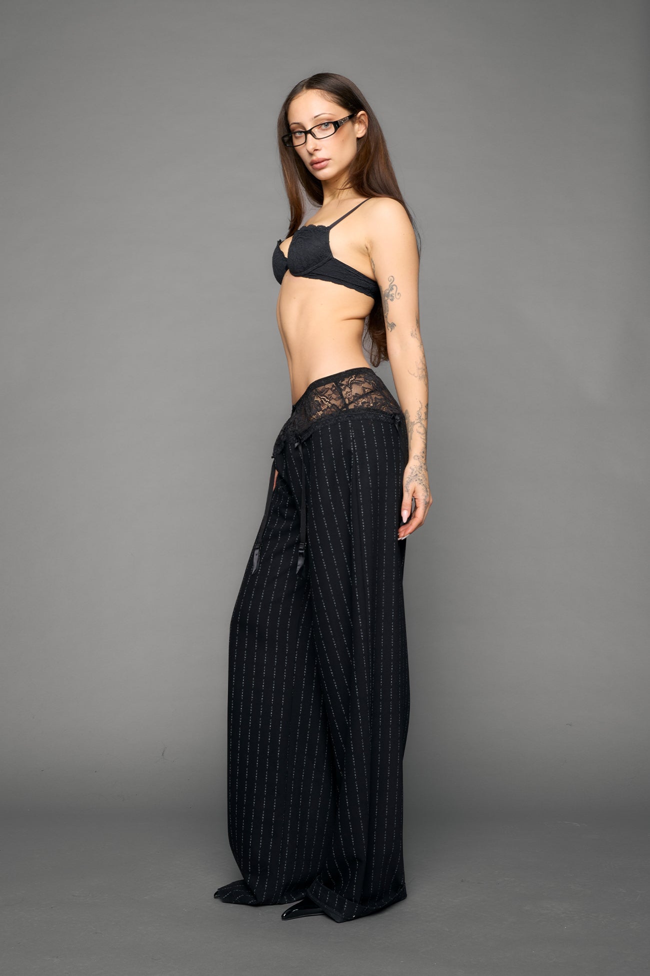 model wearing black print baggy suiting pants with garter lace waist detail