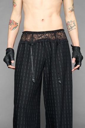 model wearing black print print baggy suiting pants with garter lace waist detail