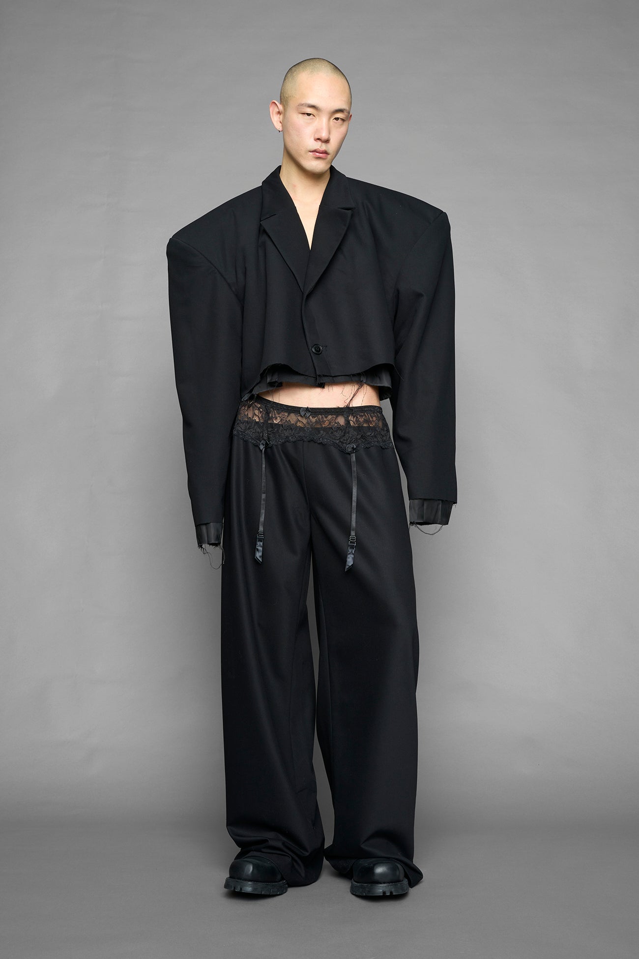 model wearing black baggy suiting pants with garter lace waist detail