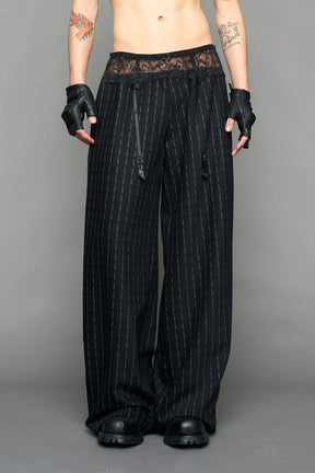 model wearing black print baggy suiting pants with garter lace waist detail