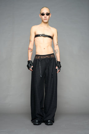 model wearing black print baggy suiting pants with garter lace waist detail
