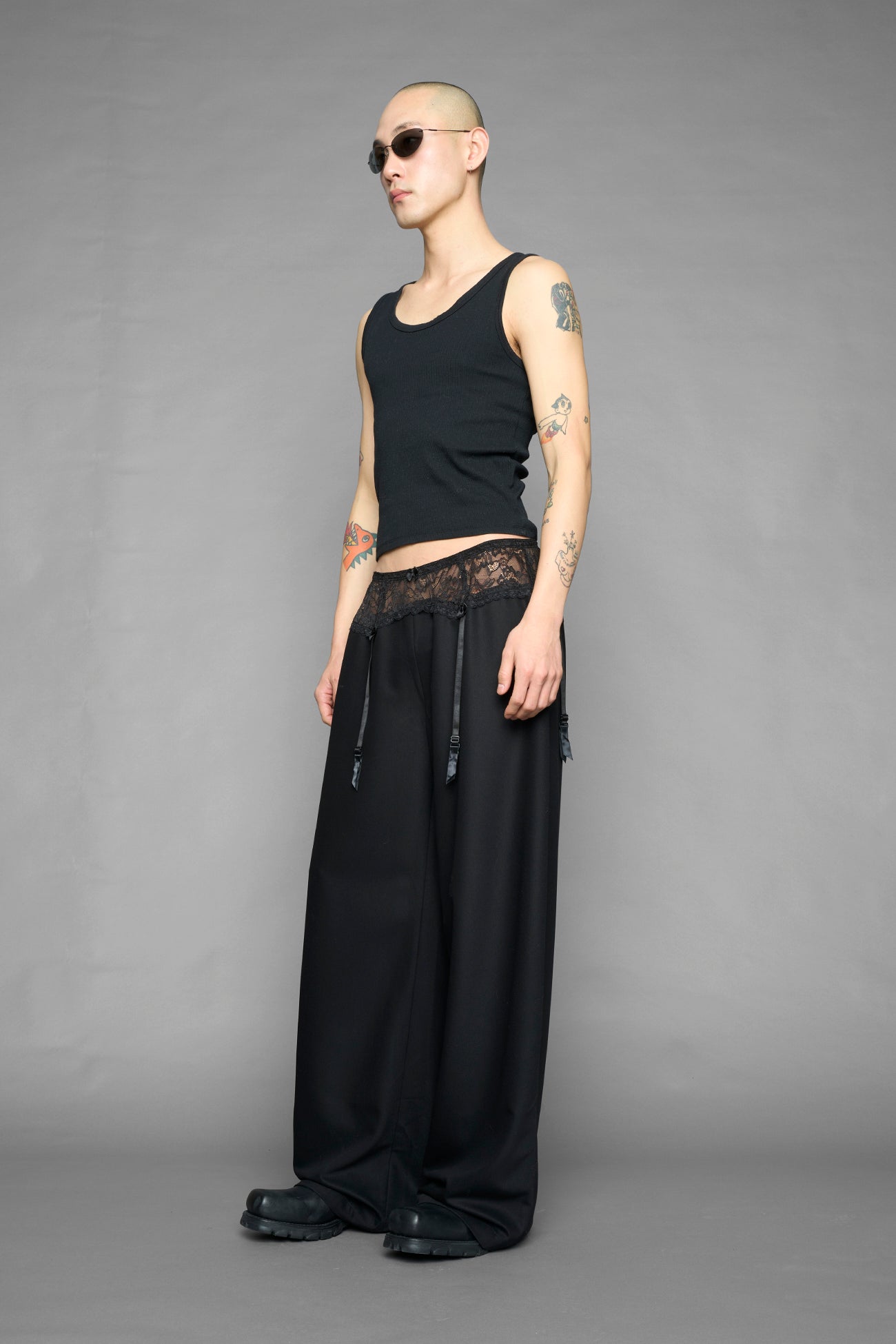 model wearing black baggy suiting pants with garter lace waist detail