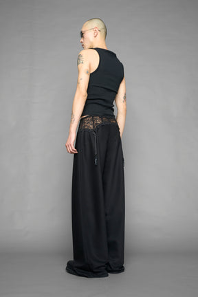model wearing black baggy suiting pants with garter lace waist detail