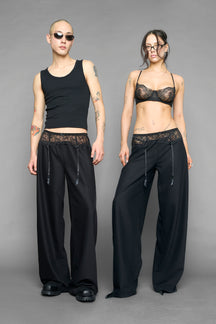 model wearing black baggy suiting pants with garter lace waist detail
